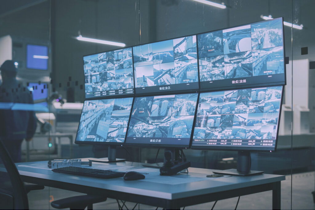 A NOC workstation with multiple monitors showing video feeds
